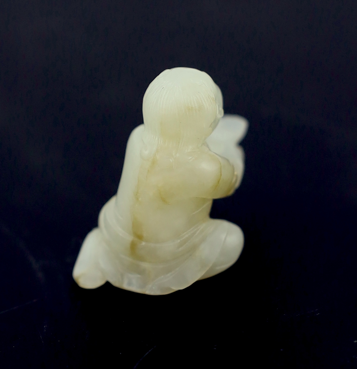 A Chinese white and russet carved jade figure of Liu Hai, 17th century